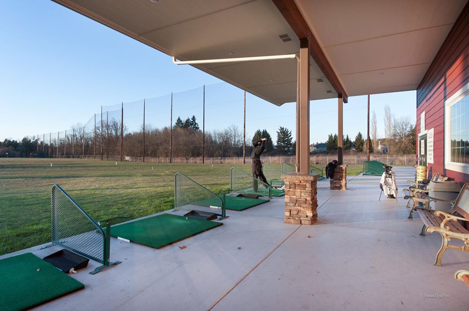 Golfer practicing at covered driving range