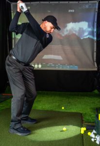 Man is practicing swinging in a simulated environment