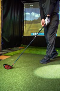 Man working on his golf swing in simulated environment